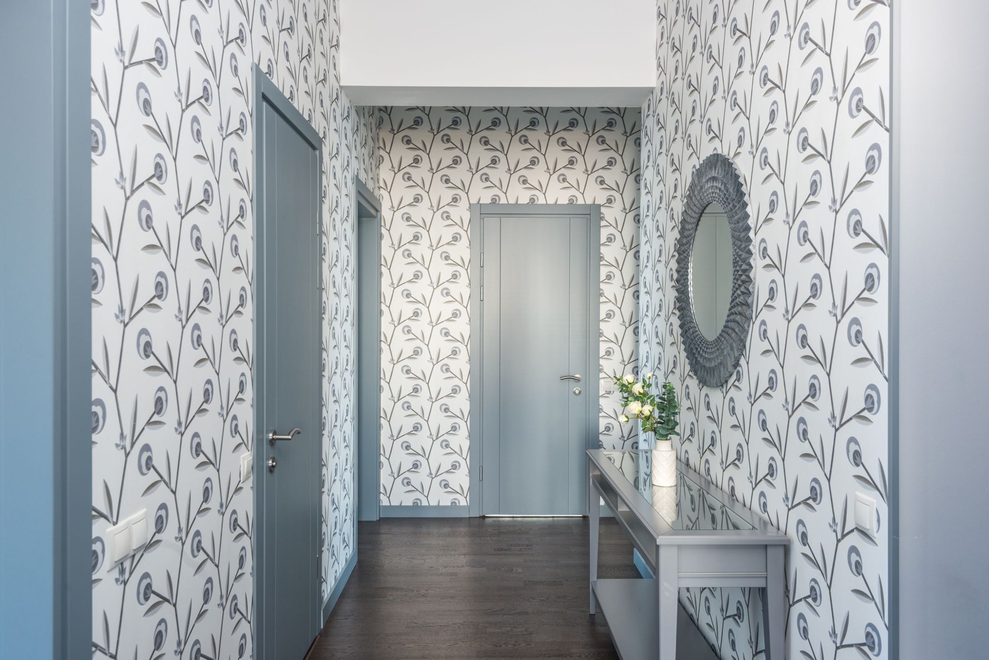 Floral wallpaper in a hallway with console table and decorative mirror